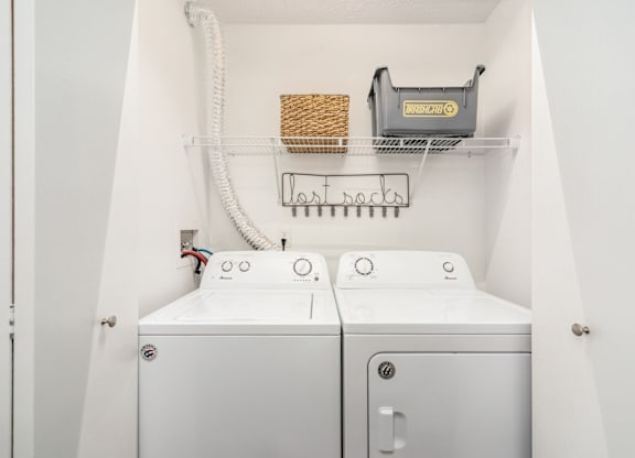A white washing machine and dryer in a small laundry room.