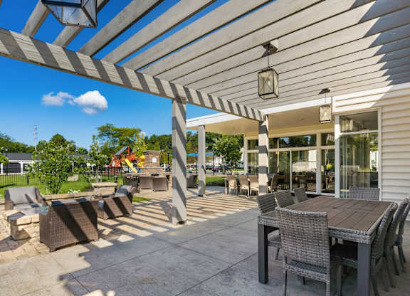 A patio with a table and chairs under a striped awning.