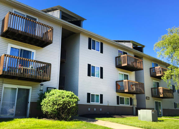 the exterior of a white apartment building with balconies at Oakwood Apartments, Florence, Kentucky