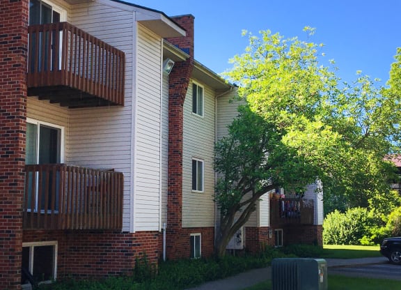 the outside of a building with a tree and a sidewalk at Oakwood Apartments, Florence, KY, 41042