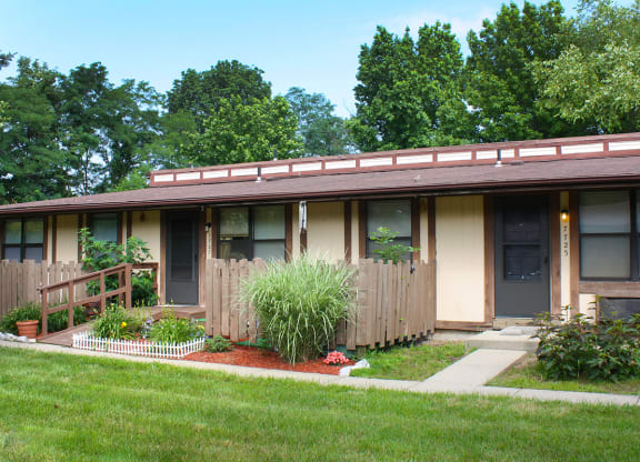 a house with a porch and plants in front of it at Wentworth Estates Apartments, Kentucky