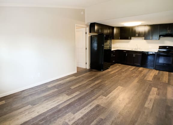 a kitchen and living room with black appliances and wood flooring at Wentworth Estates Apartments, Florence, KY