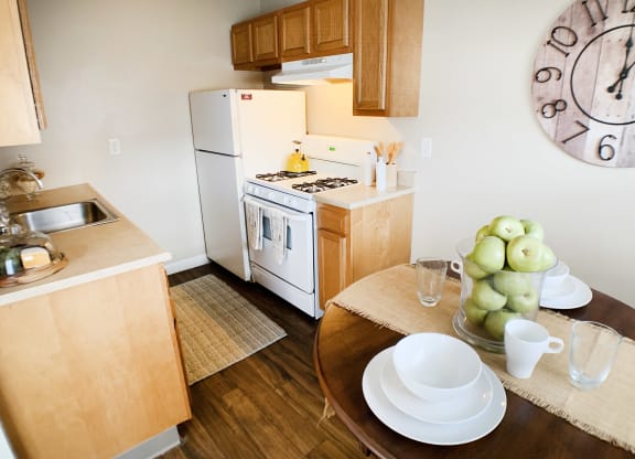 a kitchen and dining room with a large clock on the wall  at Wentworth Estates Apartments, Kentucky