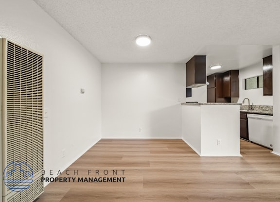 A kitchen area with wooden floors and white walls.