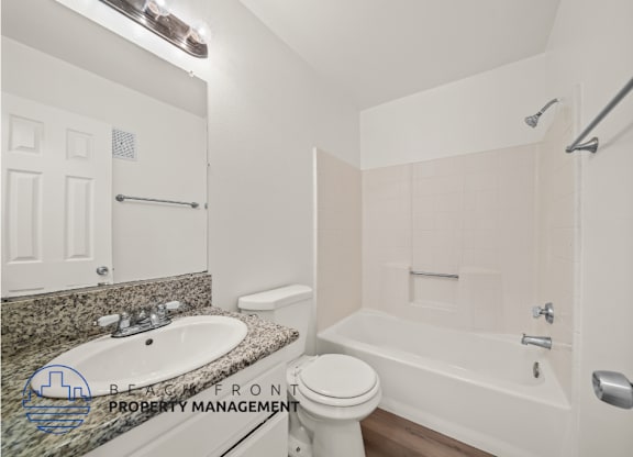 A bathroom with a sink, toilet, and bathtub.