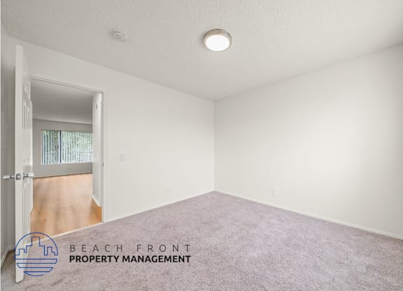 A room with a carpeted floor and a door leading to a balcony.