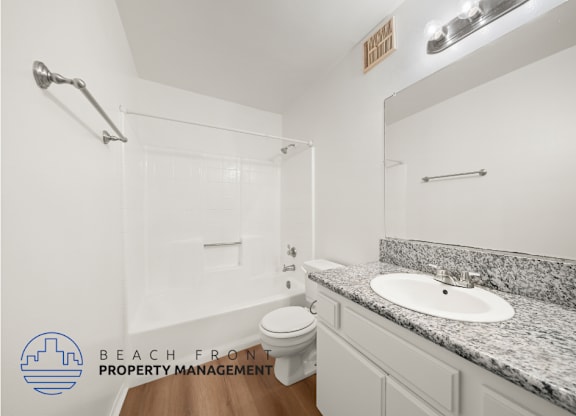 A bathroom with a granite countertop and a white sink.