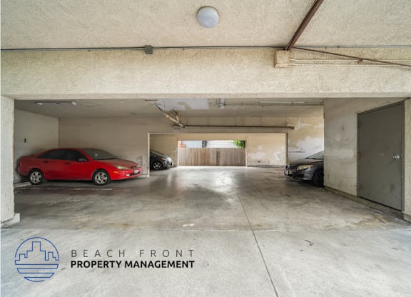 A parking garage with a red car and a sign that says