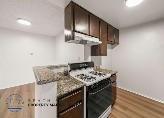 A kitchen with a stove top oven and a range hood.