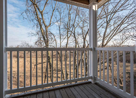 A view from a porch looking out to a wooded area.