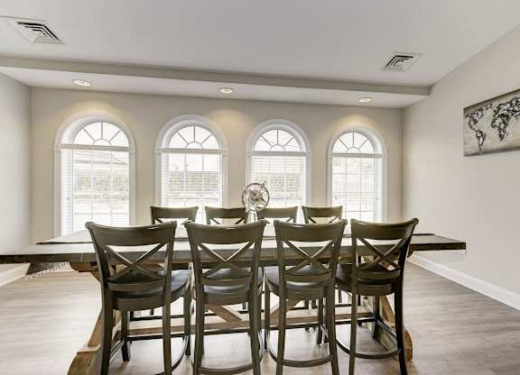 A dining room with a table and chairs.