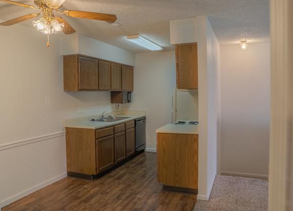 A kitchen with wooden cabinets and a ceiling fan.