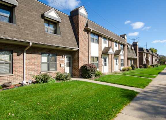 A row of homes with green lawns in front.