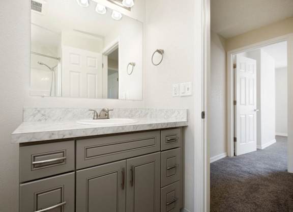 View of Bathroom Vanity with Grey Cabinets, Mirror, and Lighting at Woodlake Townhomes, Edmonds, WA