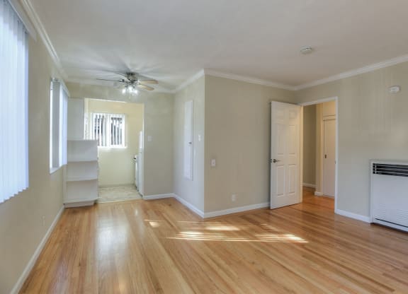A room with wooden floors and a ceiling fan.