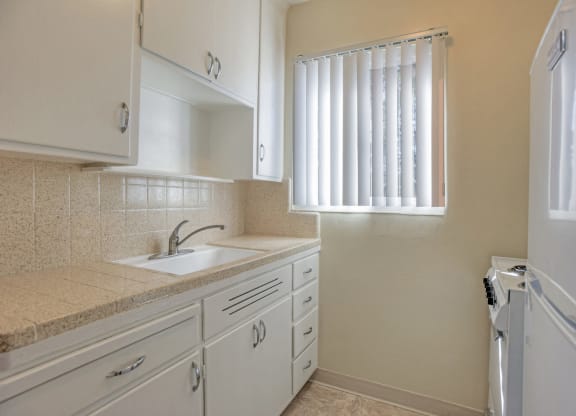 A kitchen with white cabinets and a sink.