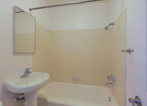 A white sink is next to a bathtub in a bathroom.