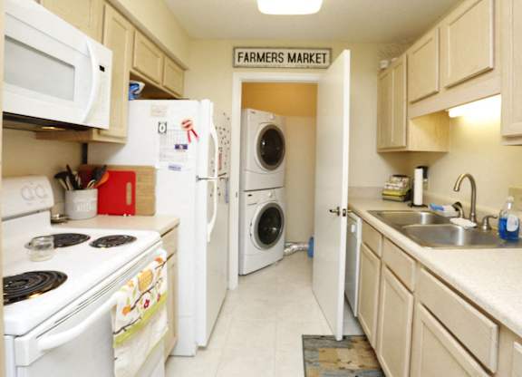 a kitchen with a washing machine and a washer and dryer in it