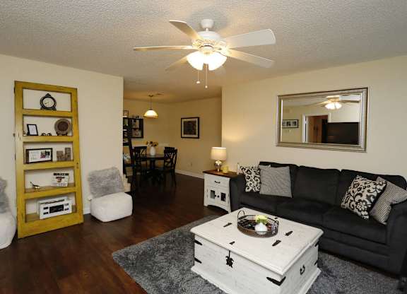 an open living room with a black couch and a coffee table