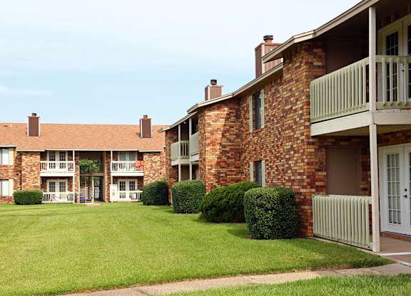 an apartment building with a lawn and a balcony