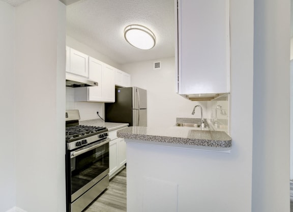 a kitchen with white cabinets and stainless steel appliances at Avondale Overlook, Hyattsville, Maryland