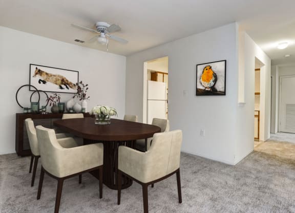 a dining room with a table and chairs and a ceiling fan