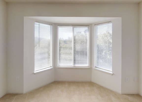 an empty room with three windows in it