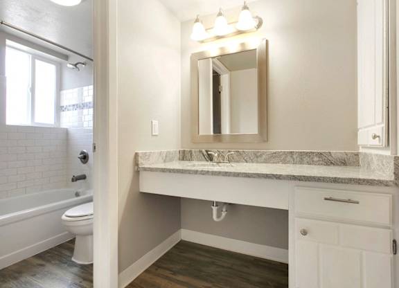 a bathroom with a sink and a toilet and a mirror at Park at Fitzsimons Apartments, Colorado, 80011