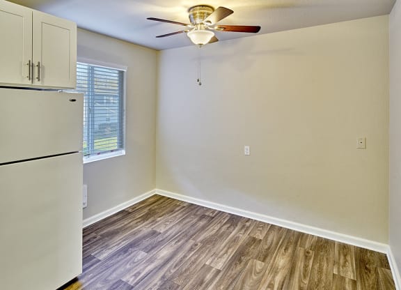 Dining area with ceiling fan, wood style flooring and window.at Woodhaven, Everett, 98203
