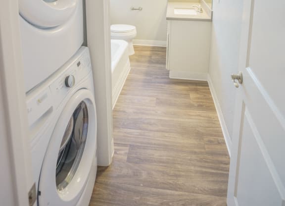 a washer and dryer in a bathroom with a sink and a toilet