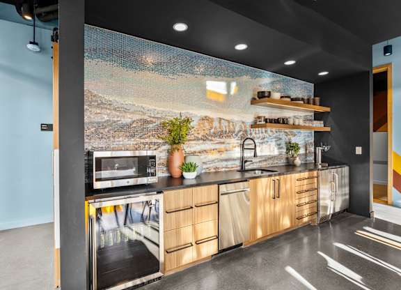 A kitchen with a large painting on the wall.