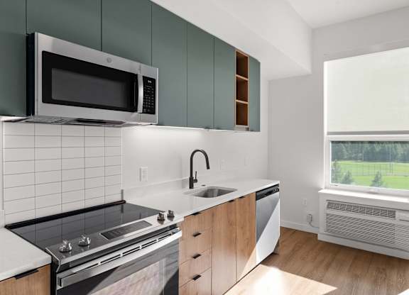 A modern kitchen with a black microwave above the stove.