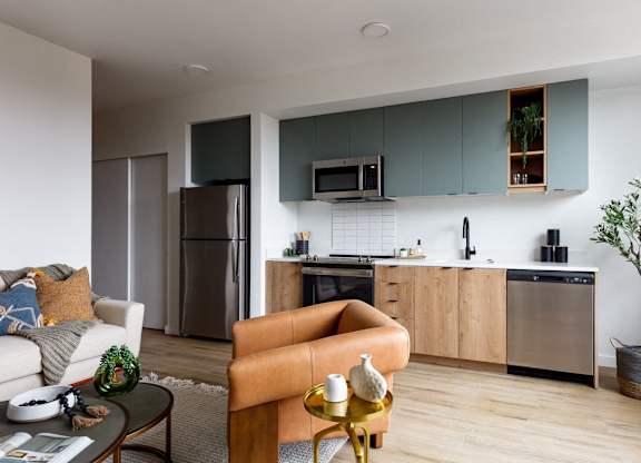 A modern kitchen with a refrigerator, oven, and microwave.