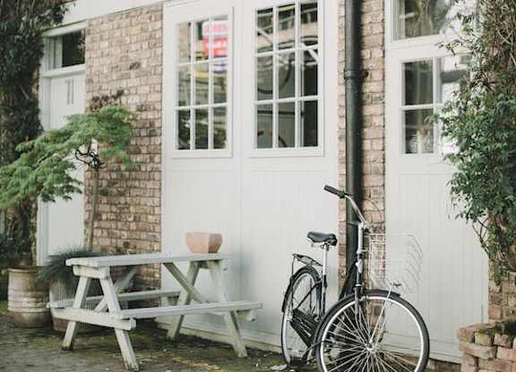 A bicycle is parked next to a white door.