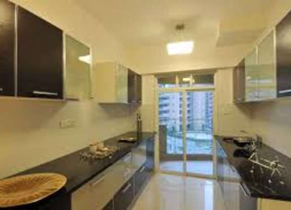 A modern kitchen with black countertops and stainless steel appliances.