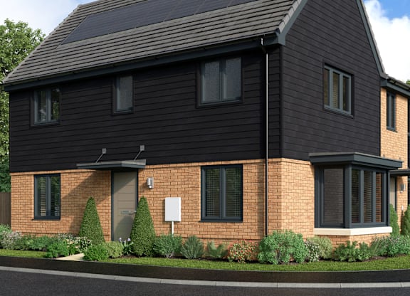 A house with a black roof and a brick chimney.