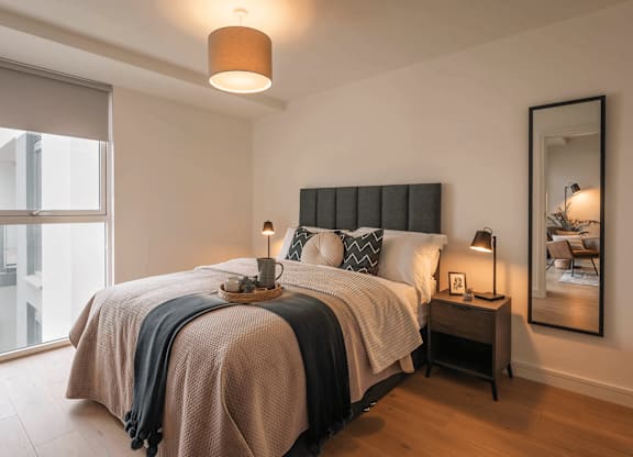 A bedroom with a large bed and a large window. at Cherrywood Apartments, D18 VY3V