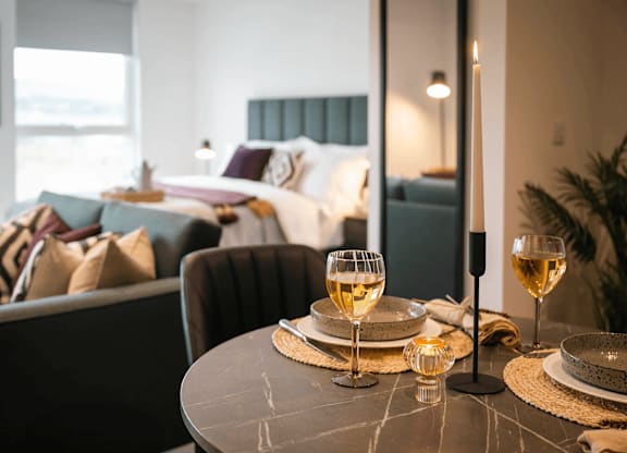 A dining table set with two glasses of white wine. at Cherrywood Apartments, D18 VY3V