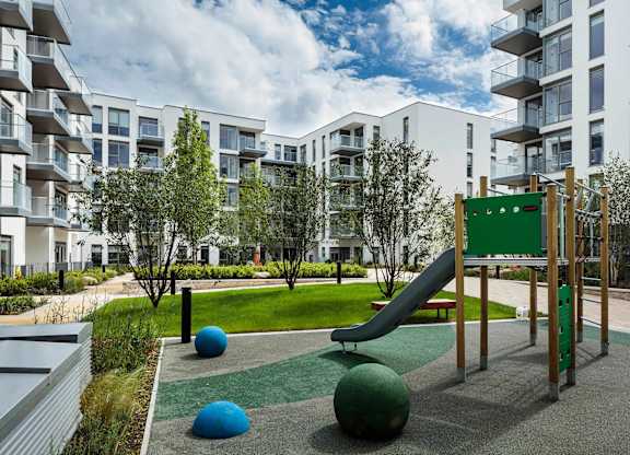 A playground with a green slide and blue and green balls. at Cherrywood Apartments, D18 VY3V