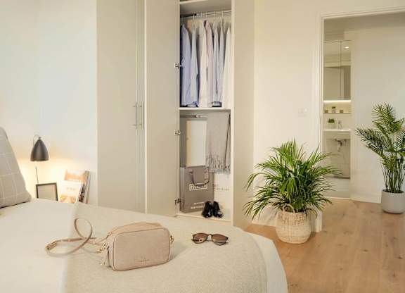 A white bed with a pink purse and sunglasses on it. at Cherrywood Apartments, D18 VY3V, DUBLIN 18