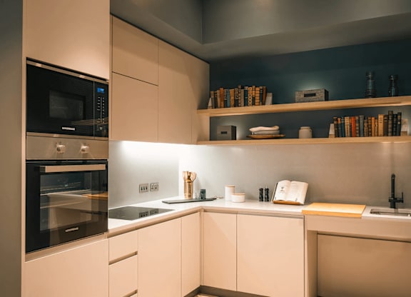 A modern kitchen with a black oven and white cabinets. at Cherrywood Apartments, D18 VY3V