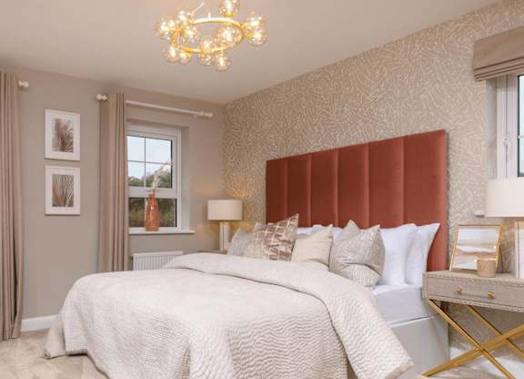 A bedroom with a large bed and a chandelier.
