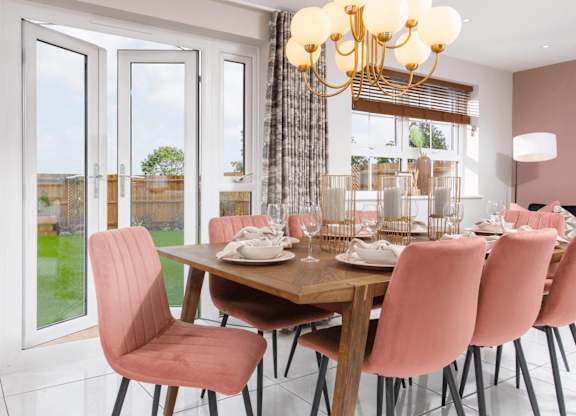A dining room with a table set for six and a chandelier.