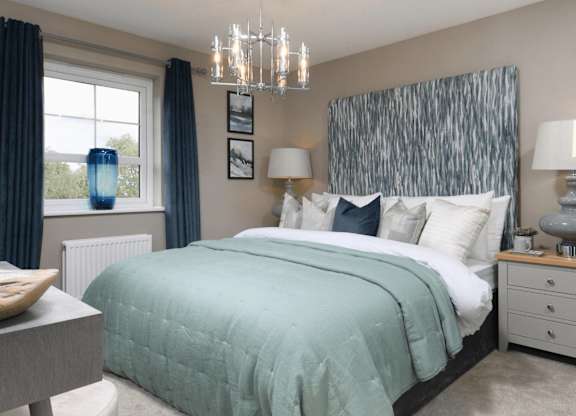 A bedroom with a large bed and a chandelier.
