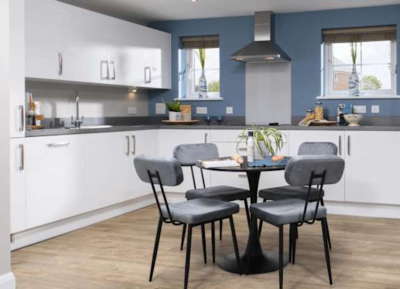 A kitchen with a table and chairs in the middle.