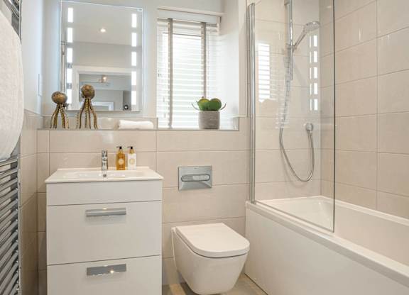 A white bathroom with a toilet, sink, and bathtub.