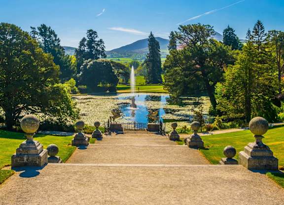 A beautiful garden with a fountain in the middle of a pond surrounded by statues. at Cherrywood Apartments, D18 VY3V