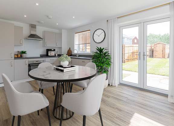A modern kitchen with a round table and chairs.