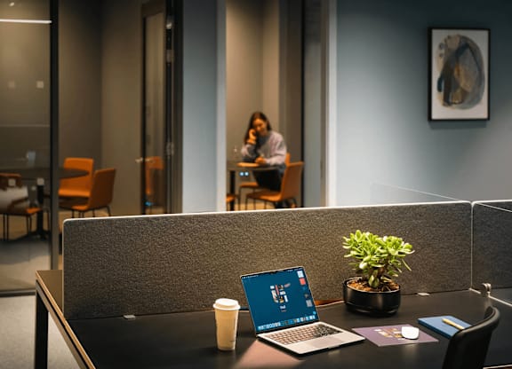 A laptop is open on a desk with a plant and a cup of coffee. at Cherrywood Apartments, D18 VY3V, DUBLIN 18