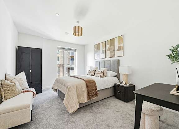 A bedroom with a bed, a chair, and a table.